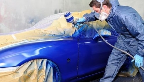 A Man Painting A Car